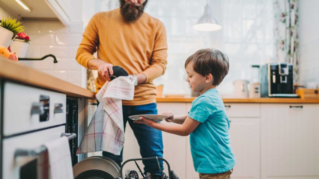 un uomo e un bambino in una cucina che lavano i piatti