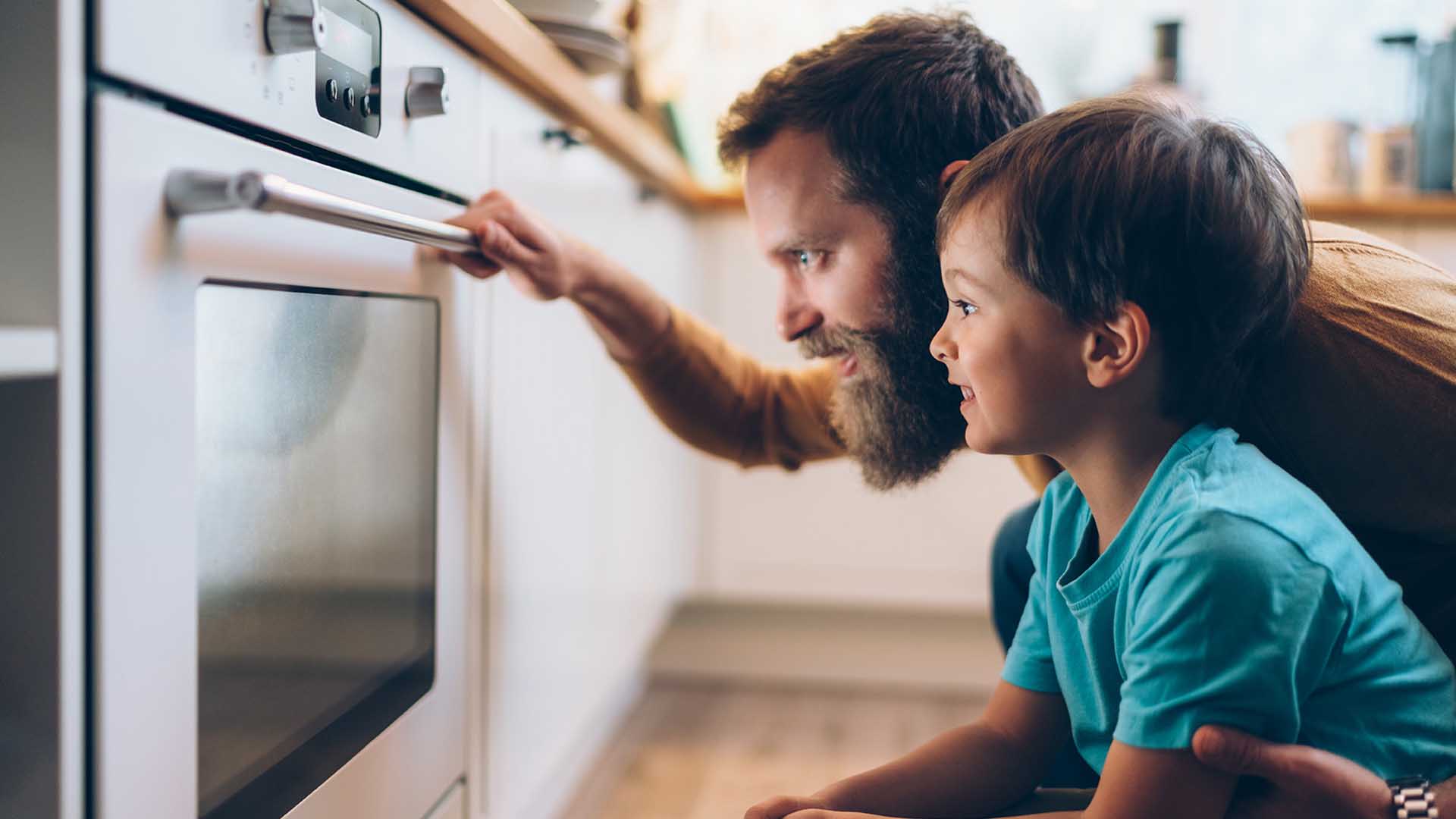 un uomo e un bambino guardano un forno