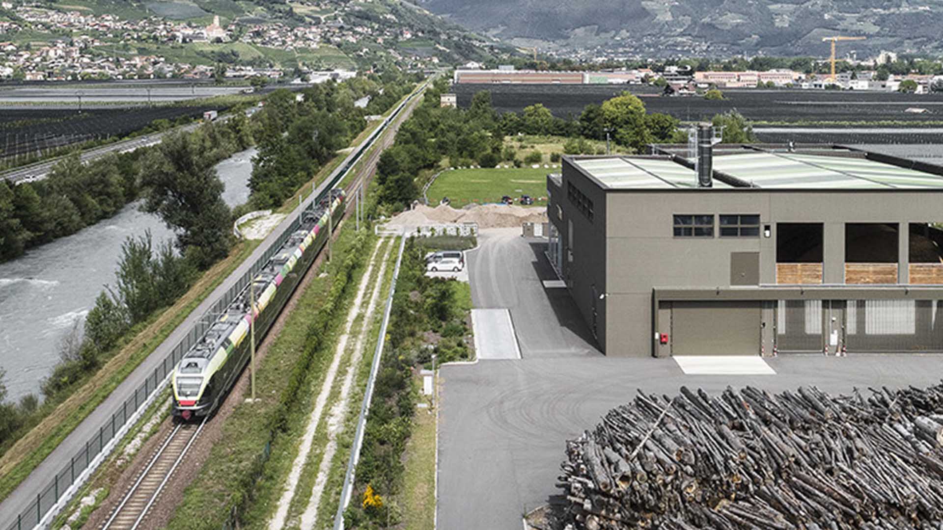 un treno passa vicino a una centrale di teleriscaldamento