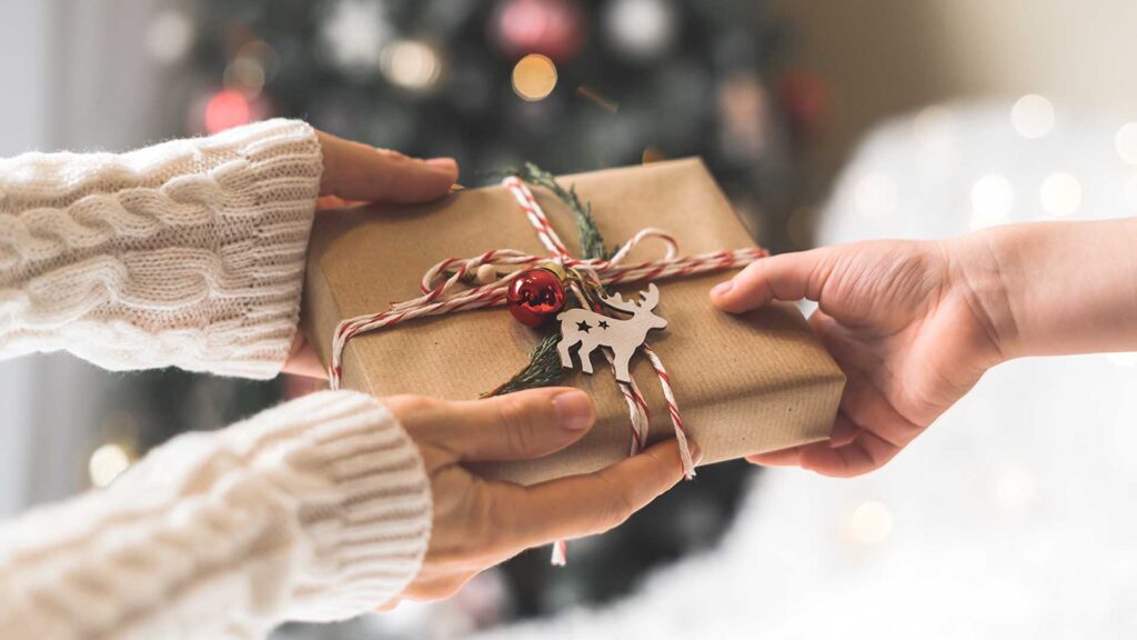 Hände halten ein verpacktes Geschenk