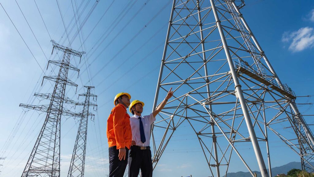 a man in hardhats pointing at a tower