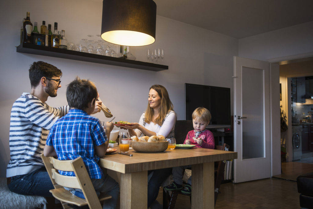 a family sitting at a table eating food