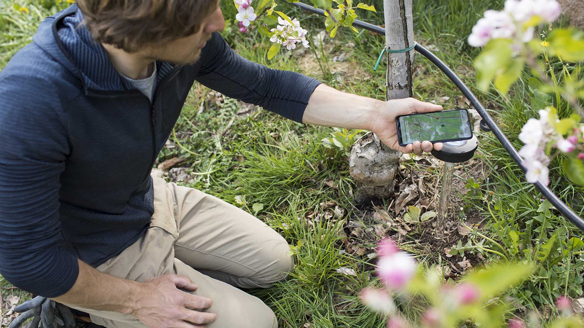 a man kneeling down holding a phone