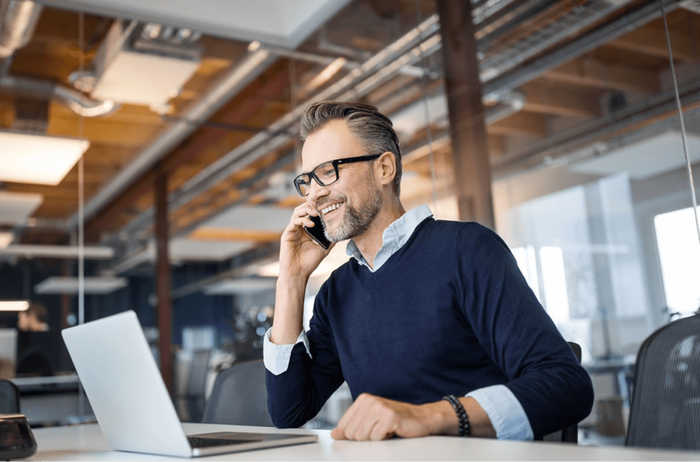 un uomo che parla al telefono con laptop