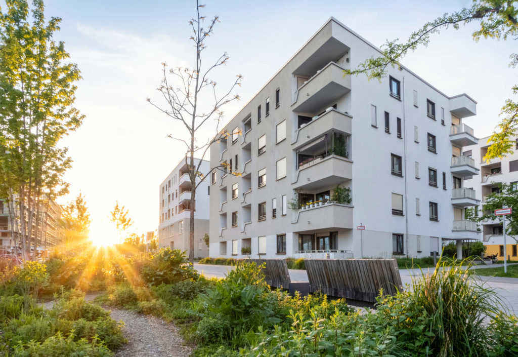 un edificio con alberi e piante di fronte