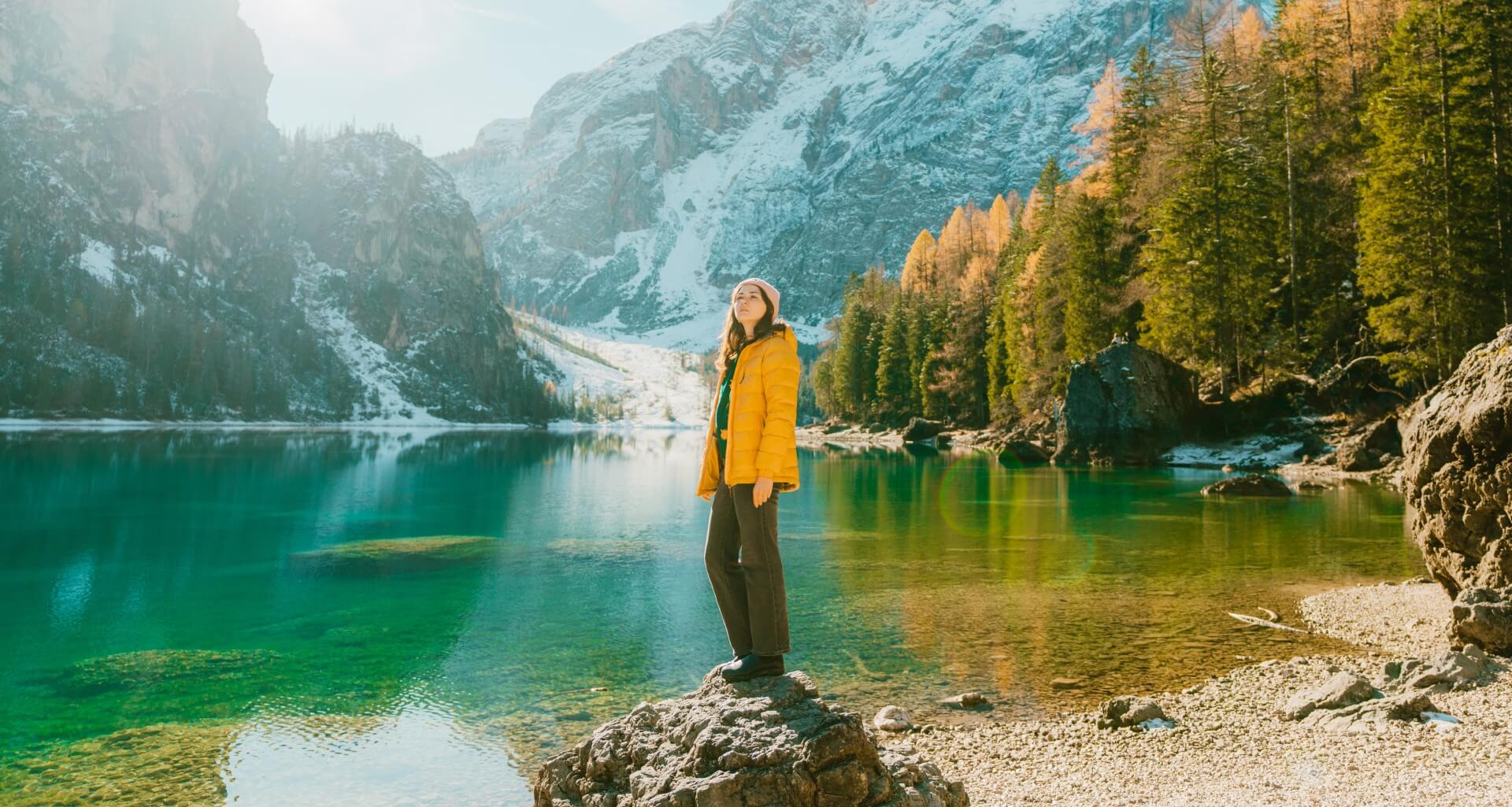 una donna su una roccia vicino a un lago