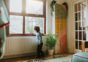 Bambina gioca con un giocattolo sul termosifone