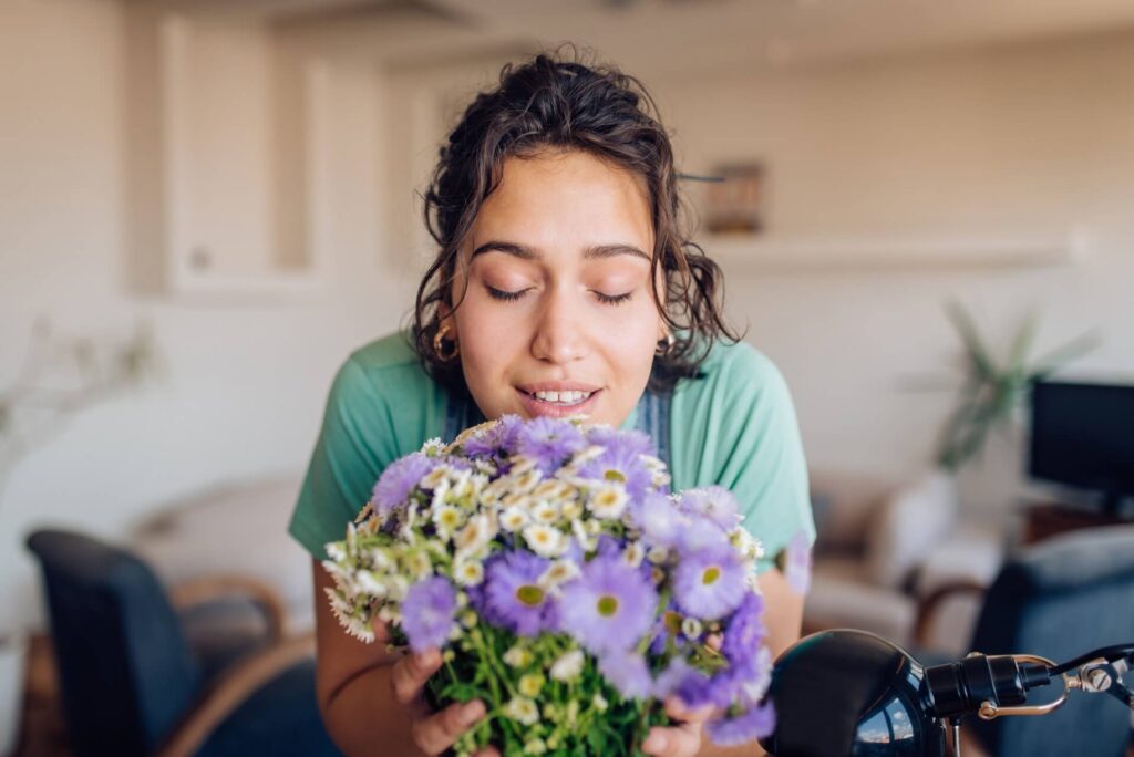 ragazza che annusa dei fiori viola