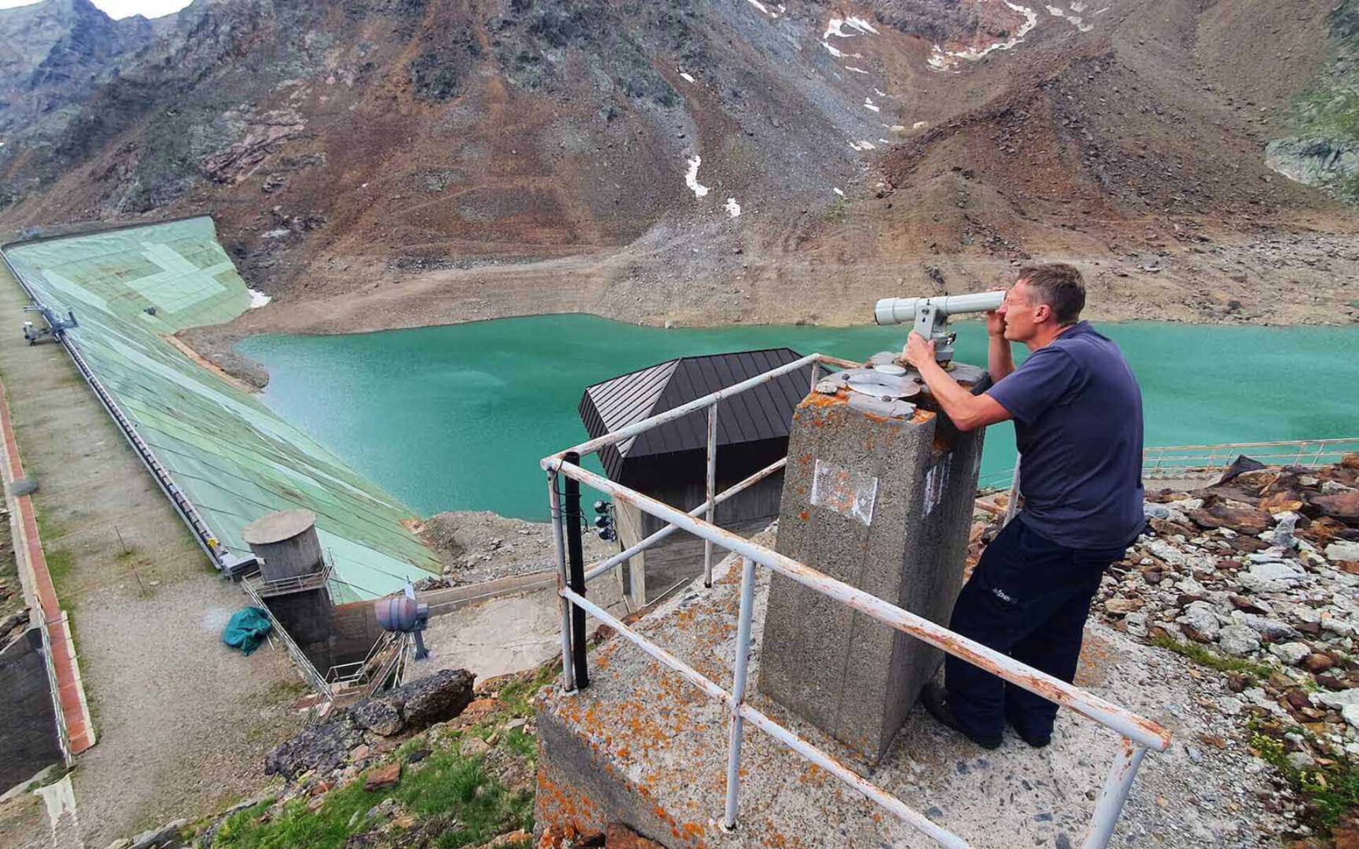 un uomo che guarda attraverso un telescopio una diga